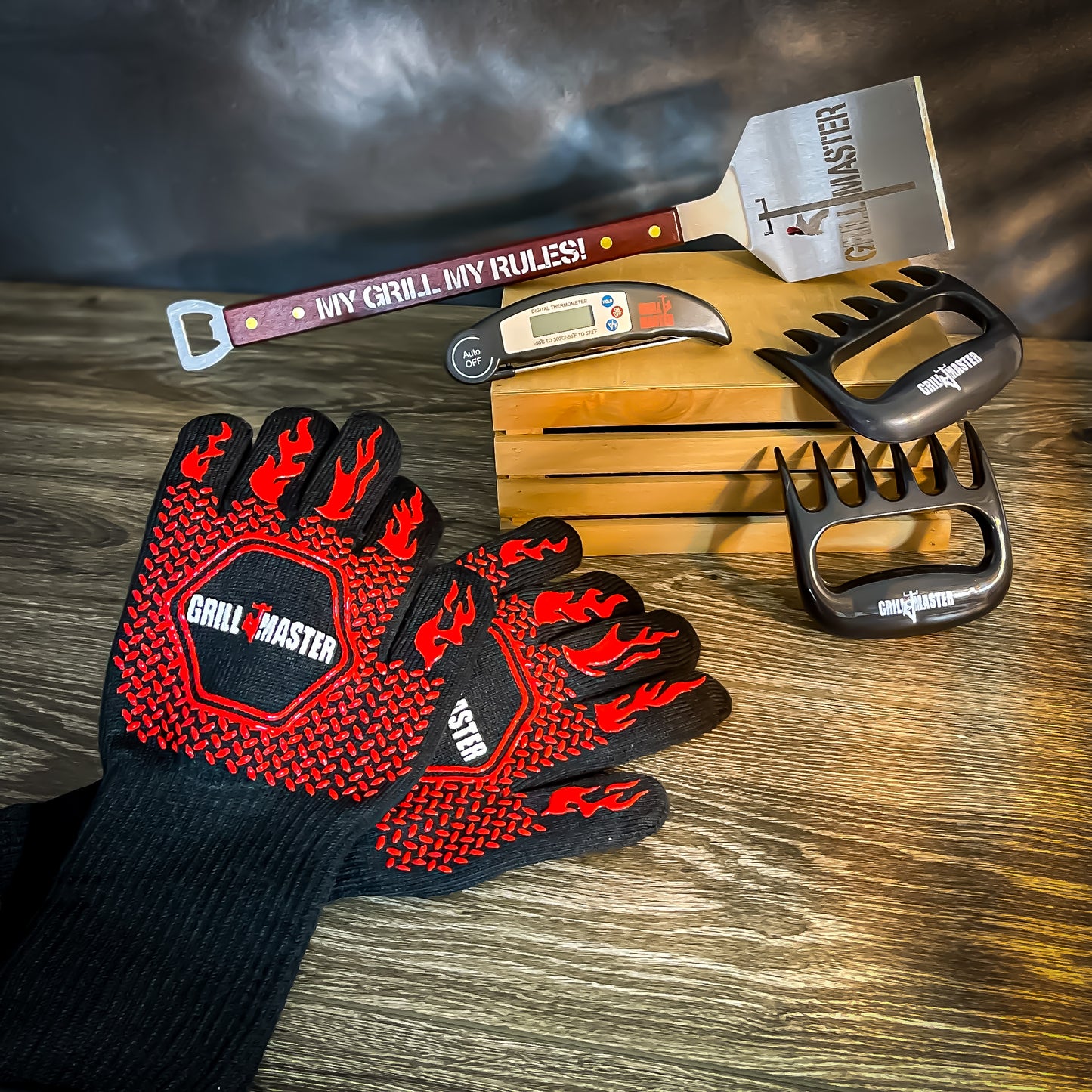 LineMan BBQ set including spatula, heat-resistant gloves, meat claws, and thermometer displayed on a table.