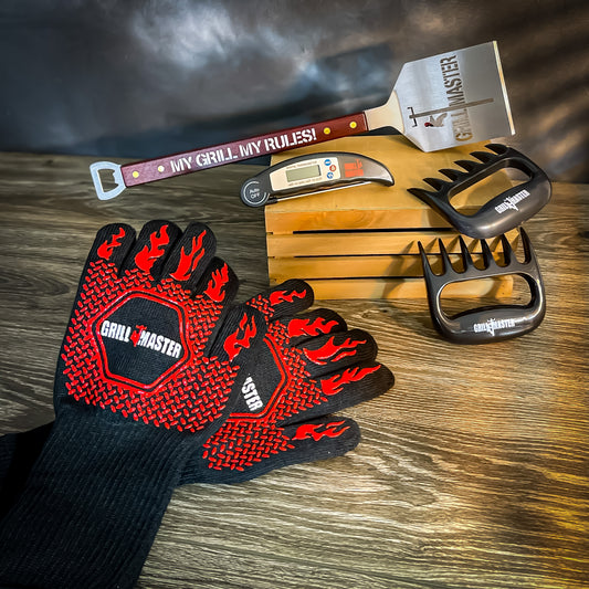 LineMan BBQ set including spatula, heat-resistant gloves, meat claws, and thermometer displayed on a table.