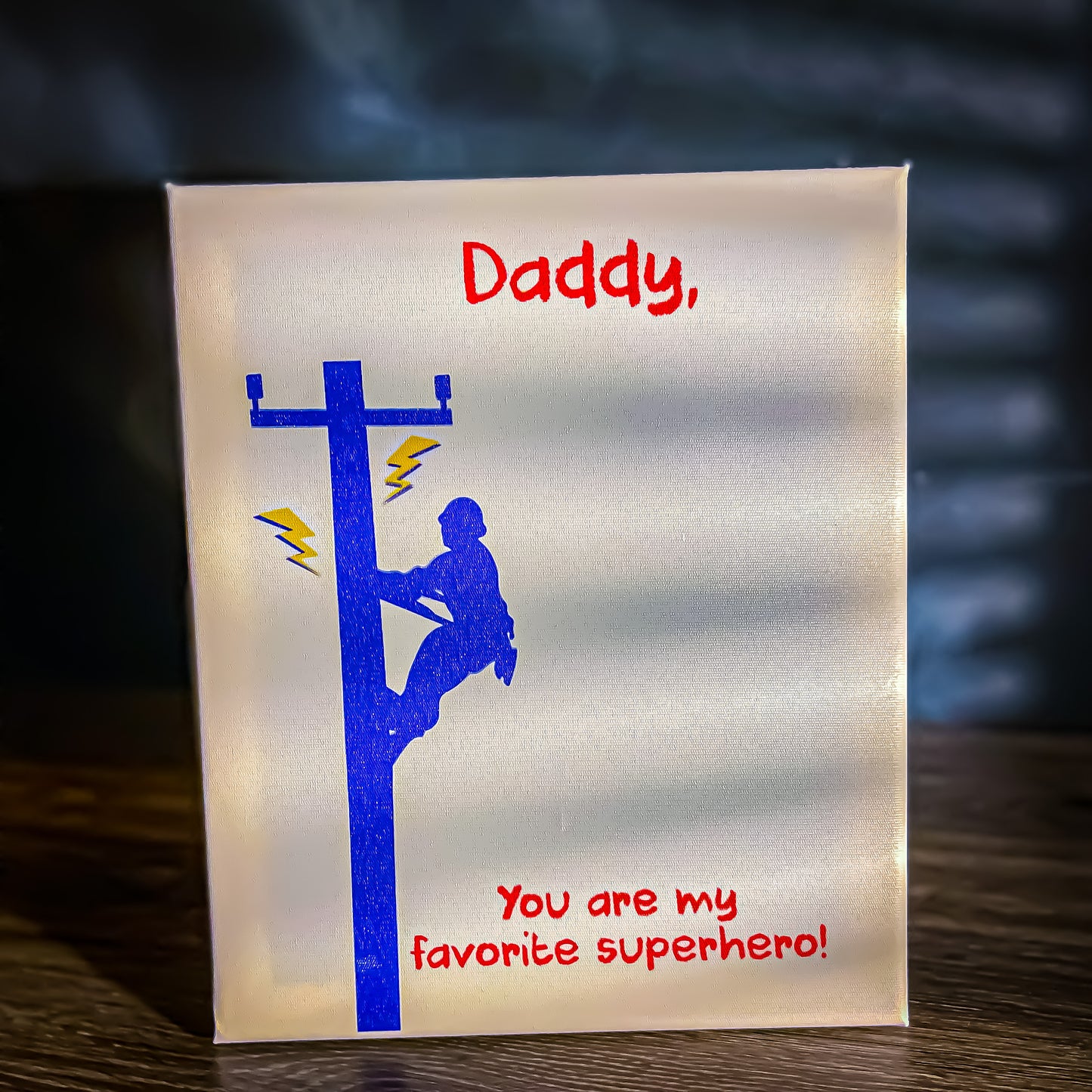 Canvas art project with a red child’s handprint for a LineMan superhero cape.