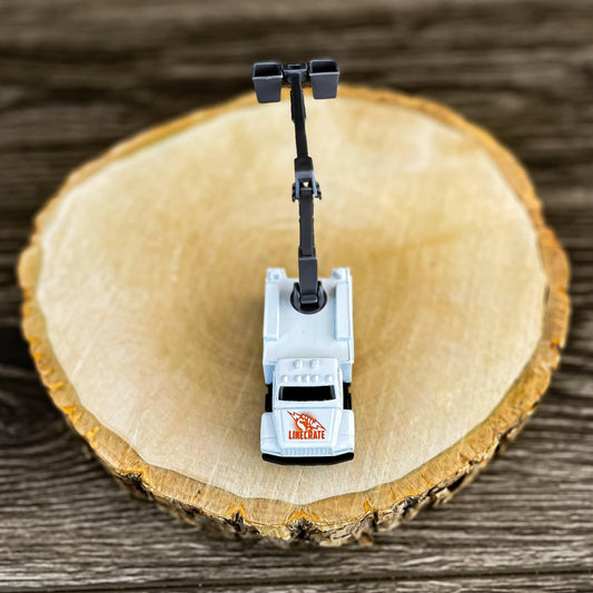 Mini bucket truck toy for LineKids, featuring a realistic boom arm, displayed on a wooden background.