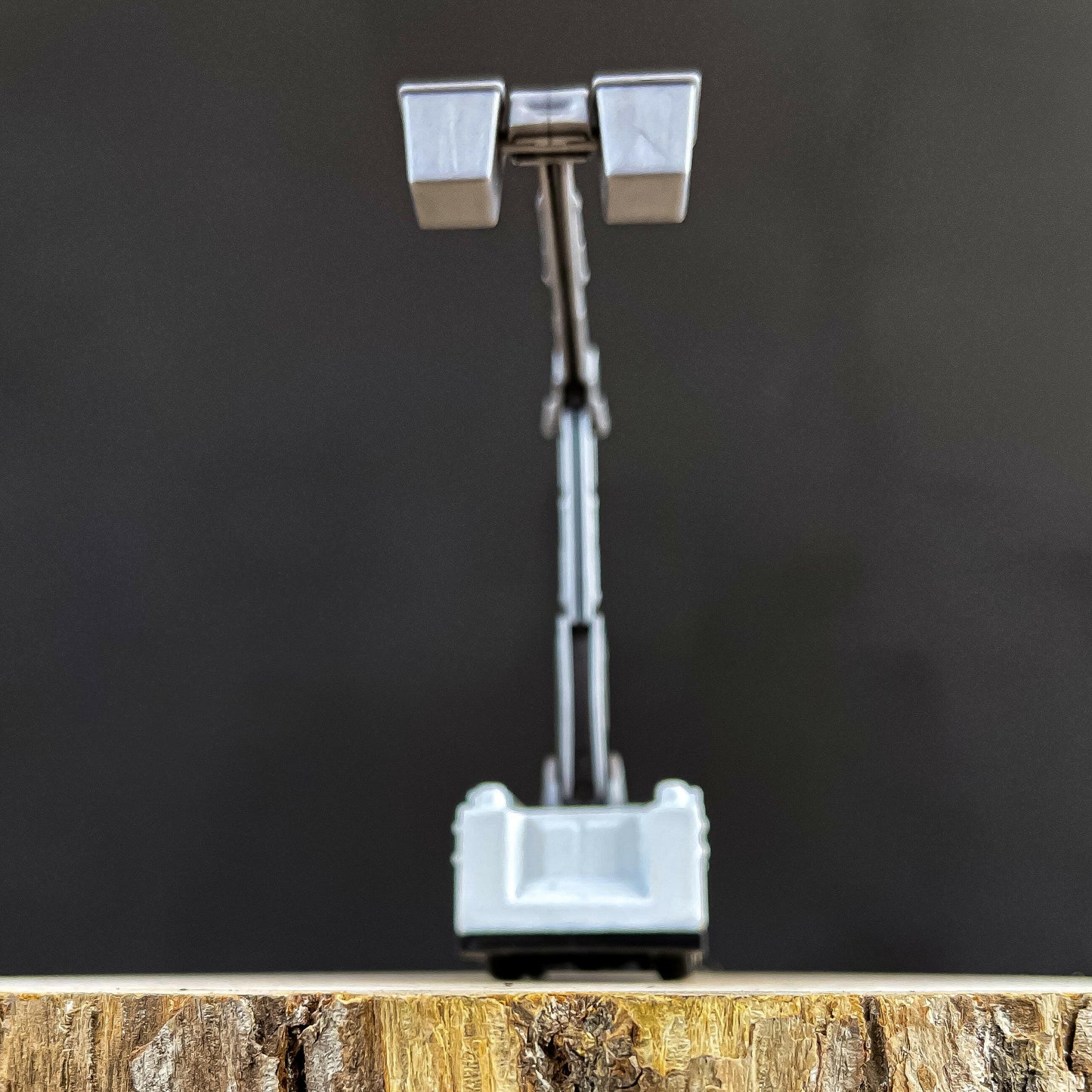 Mini bucket truck toy for LineKids, featuring a realistic boom arm, displayed on a wooden background.