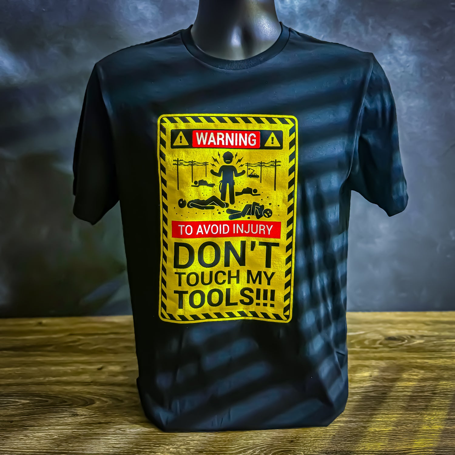 Black LineMan T-shirt with a yellow warning sign design reading 'Warning: To Avoid Injury Don't Touch My Tools' featuring a lineman and powerline graphic.