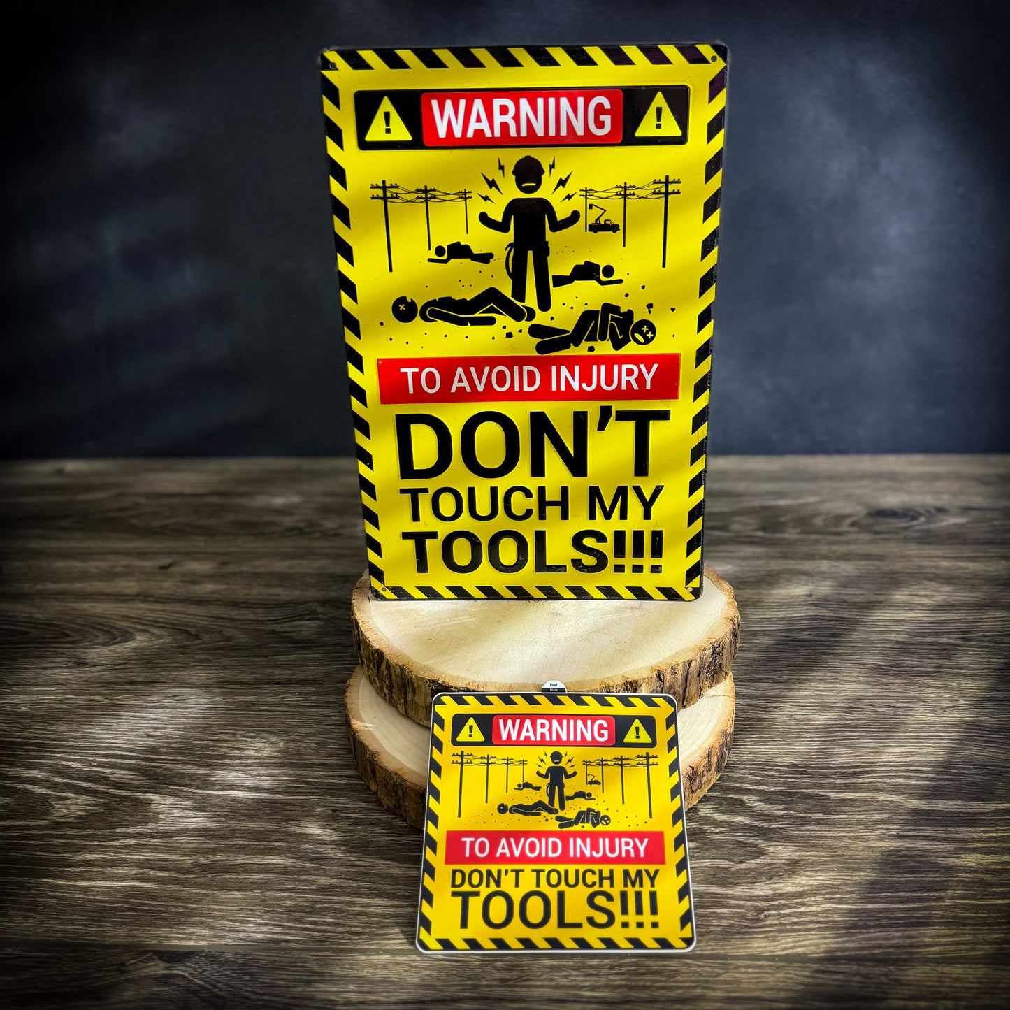 Set of two 'Don't Touch My Tools' items featuring a large warning sign and a smaller matching sticker. The large sign displays bold text with lineman and powerline graphics, and the smaller tool box sticker features the same warning design, perfect for adding to a toolbox.