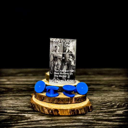 Big Duke Buttons set in blue, displayed on a wooden base with packaging in the background, reading 'You Just Got the Best Buttons on the Market - American Made,' designed for securing linemen's rubber insulating sleeves