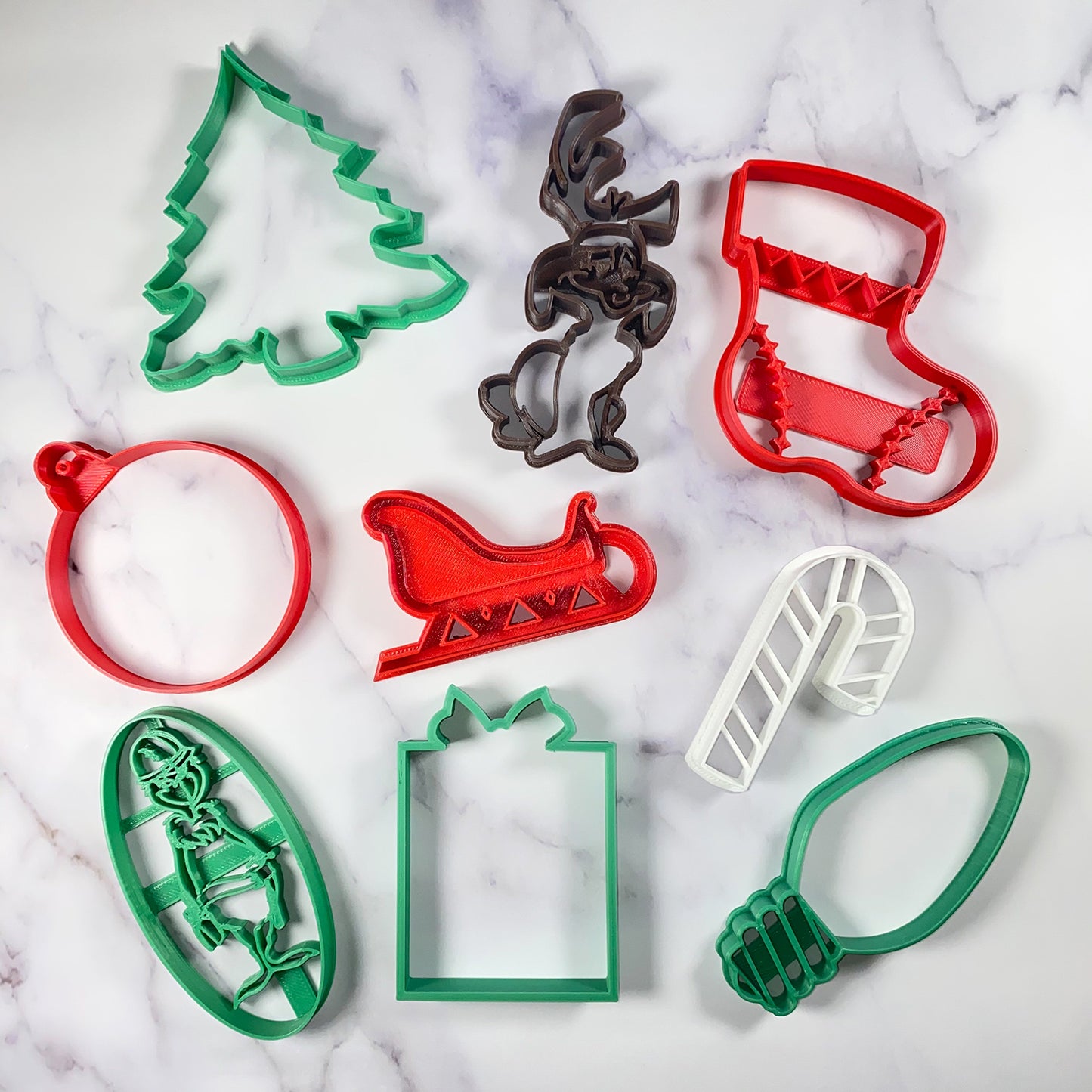 Jolly Green Lineman Holiday Cookie Cutter 9 piece Set - USA Made - Grinch Lineman, Max LinePup Dog, Christmas Tree, Christmas Twinkle Bulb Light, Holiday Ornament, Stocking, Present, Candy Cane, Sleigh on Countertop