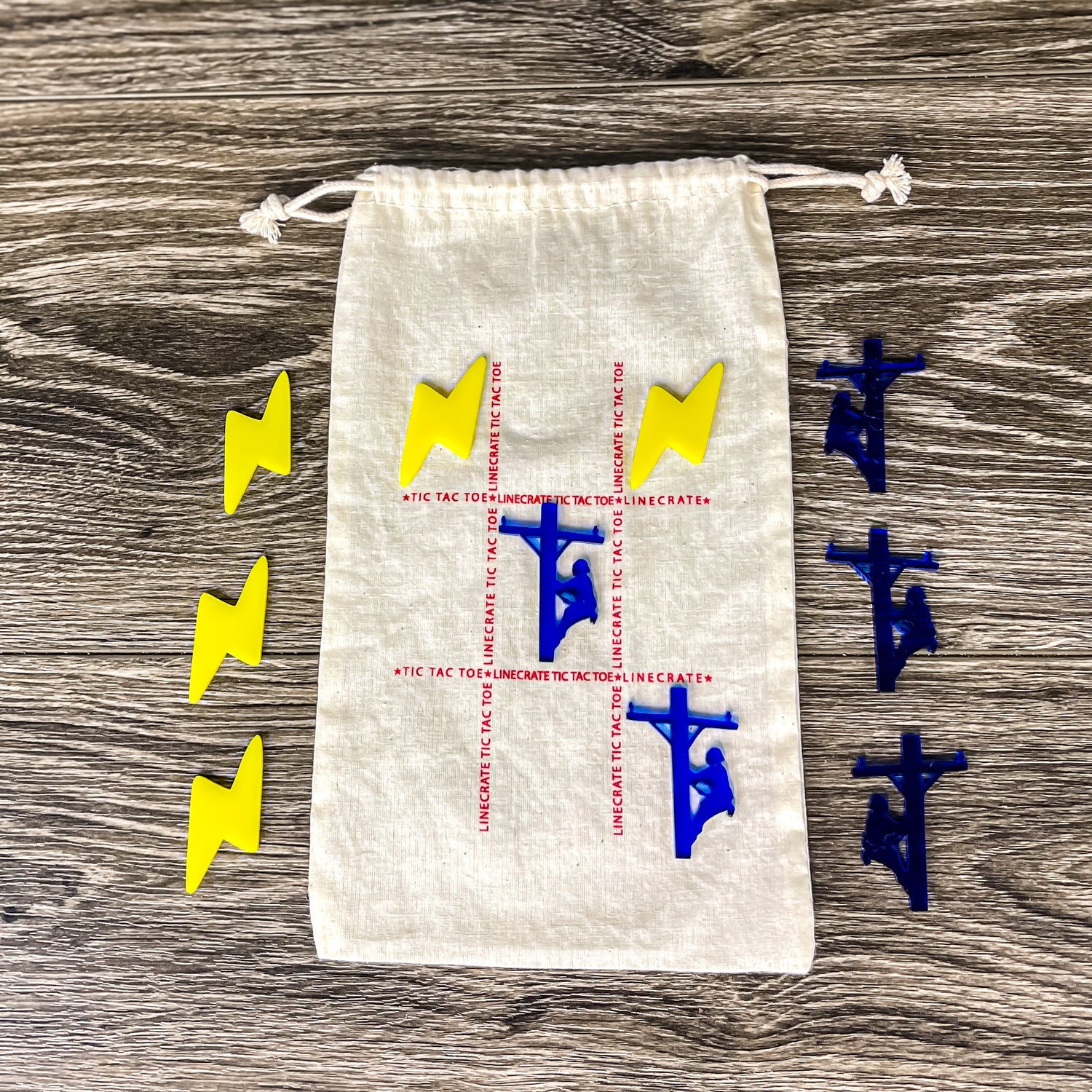 Lineman tic tac toe game and storage bag, yellow lightning bolt game pieces, and blue lineman game pieces